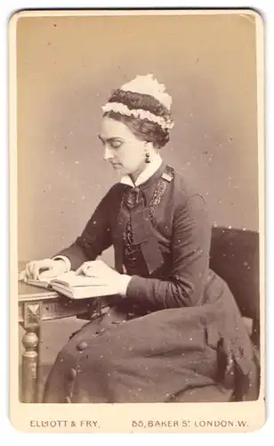 Fotografie Elliot & Frey, London, 55 Baker St., Portrait Dame im Biedermeierkleid mit Hut liest ein Buch