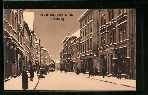 AK Mühlhausen i. Th., Strasse Steinweg mit Geschäften und Strassenbahn im Winter