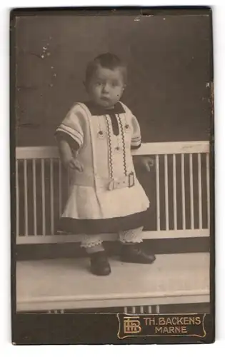 Fotografie Th. H. Backens, Marne, Kleines Kind im modischen Kleid