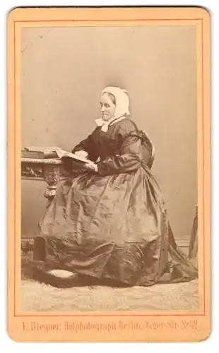 Fotografie E. Biegner, Berlin, Jäger-Str. 42, Portrait ältere Dame im Reifrock Kleid liest ein Buch im Atelier