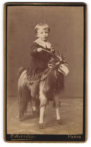 Fotografie Charles, Paris, Bould. Beaumarchais 1, Portrait kleines Mädchen im Kleid sitzt auf einer Ziegenbock Figur