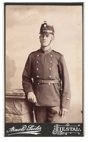 Fotografie Arnold Seiler, Liestal, Portrait schweizer Soldat in Uniform Rgt. 53 mit Tschako und Bajonett