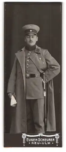 Fotografie Eugen Scheurer, Neu-Ulm, Soldat in Uniform mit Schirmmütze und Mantel