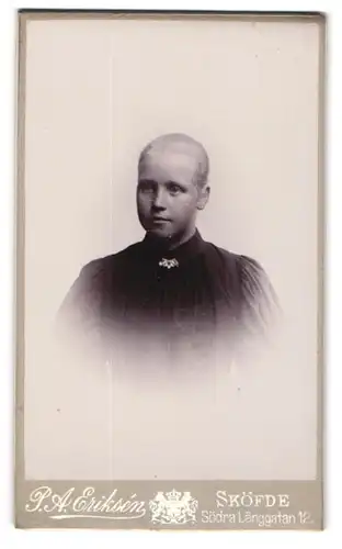 Fotografie P. A. Eriksen, Sköfde, Södra Langgatan 12, Junge Frau mit streng zurückgekämmtem Haar und Brosche