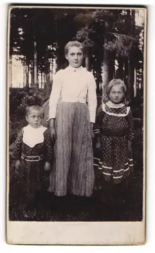 Fotografie unbekannter Fotograf und Ort, Die Geschwister Alma, Anna und Gustav im Kiefernwald