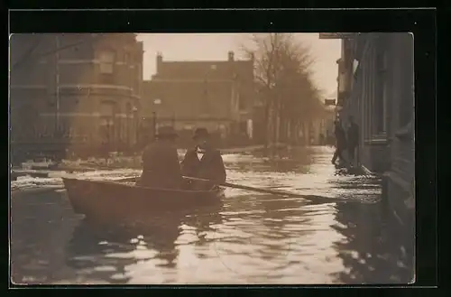 AK Koog /Zaandijk, Überflutete Strasse bei Hochwasser, Männer im Paddelboot