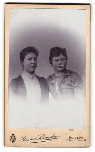 Fotografie Gustav Schwedes, Heide i. H., Friedrichstr. 42, Portrait zwei hübsche junge Frauen in eleganten Kleidern