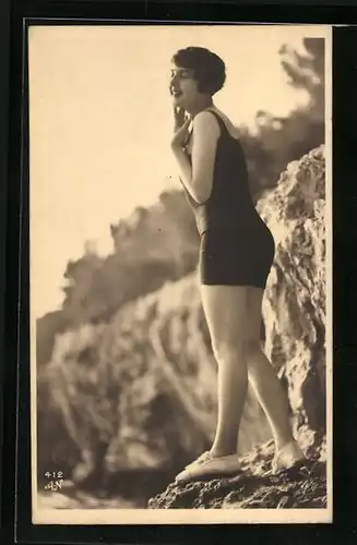 AK Junge Frau steht im Badeanzug auf einem Felsvorsprung