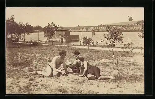 Foto-AK Junger Mann mit hübschen Damen im Badeanzug auf der Wiese