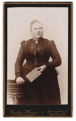 Fotografie Gustav Haeyn, Bielefeld, Oberntorwall 25, Beleibte Dame im Kleid mit Buch in der Hand
