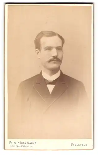 Fotografie Fritz Küken Nachf., Bielefeld, Junger Mann mit Schnurrbart und Fliege