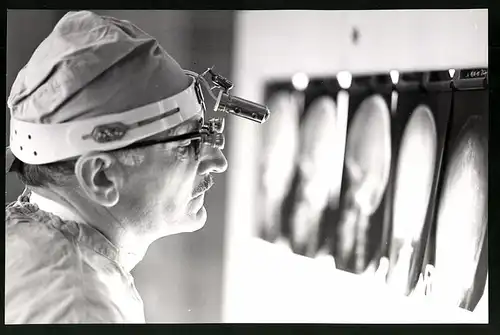 Fotografie Helmut Raddatz, Berlin-Weissensee, Chirurg betrachtet Röntgenbilder eines Schädel's im Klinikum Berlin-Buch