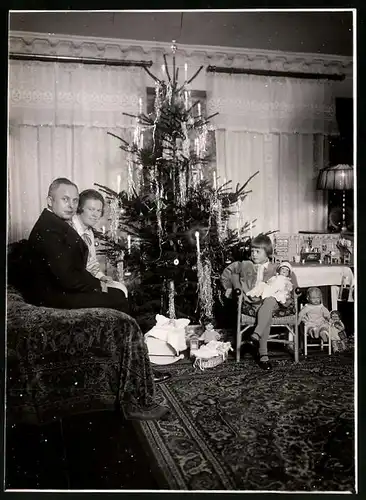 Fotografie Weihnachten, Mädchen mit Puppe & Puppenstube am Weihnachtsbaum sitzend