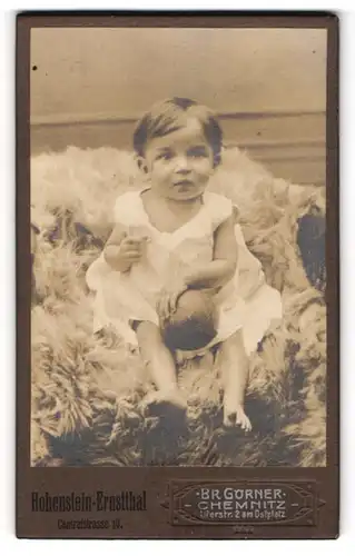 Fotografie Br. Görner, Chemnitz, Uferstr. 2 am Ostplatz, Kleines Kind im Hemd mit Ball sitzt auf Fell