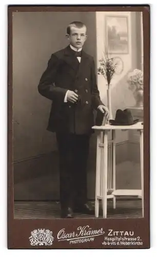 Fotografie Oscar Krämer, Zittau, Hospitalstr. 2, Portrait junger Knabe im schwarzen Anzug mit Hut und Bibel, Kommunion