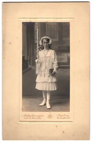 Fotografie Atelier Germania, Augsburg, Portrait Mädchen Elsa Settele im Kommunionskleid mit Haarschmuck und Kerze