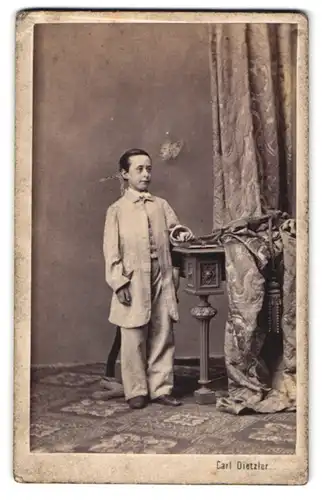 Fotografie Carl Dietzler, Wien, Portrait kleiner junger Mann im Anzug posiert stolz im Atelier