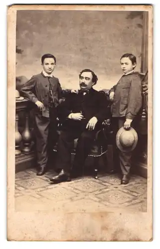 Fotografie F. K. Strezek, Wien, Portrait Vater im Anzug mit seinen beiden Söhnen im Atelier