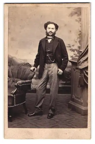 Fotografie F. K. Strezek, Wien, Portrait junger Mann im Anzug mit Backenbart und Locken