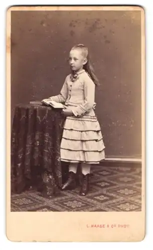 Fotografie L. Haase & Co., Berlin, Unten den Linden 62, Portrait junges blondes Mädchen im gerafften Kleid mit Buch