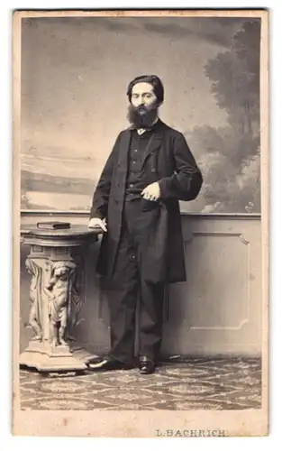 Fotografie L. Bachrich, Wien, Portrait Herr im Anzug mit buschigem Vollbart posiert im Atelier