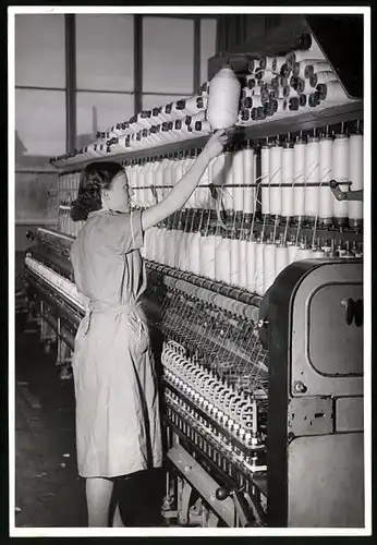 Fotografie junge Fabrikarbeiterin bestückt Spinnmaschine einer Textilfabrik
