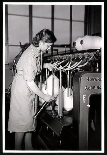 Fotografie Fabrikarbeiterin einer Textilfabrik bestückt Maschine mit einer neuen Garnspindel