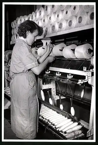 Fotografie Textilfabrik, Fabrikarbeiterin fädelt eine neue Garnrolle in Spinnmaschine ein