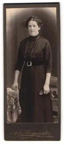 Fotografie Alb. Burgemeister, Pfullingen, Junge Frau mit kunstvoller Frisur in gegürtetem Kleid
