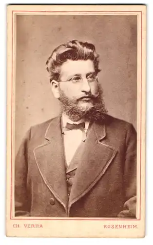 Fotografie Ch. Verra, Rosenheim, Zimmerstr. 209, Portrait Herr im Anzug mit Fliege und Vollbart trägt Brille