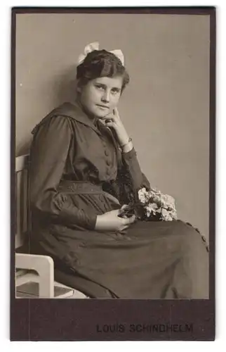 Fotografie Louis Schindhelm, Ebersbach i. S., Portrait junge Frau im dunklen Kleid mit Haarschleife und Blumen