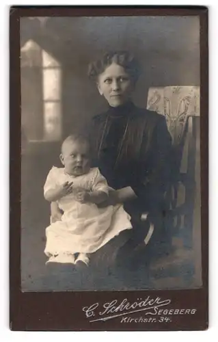 Fotografie C. Schröder, Segeberg, Kirchstr. 34, Portrait Mutter im dunklen Kleid mit Töchterchen auf dem Schoss