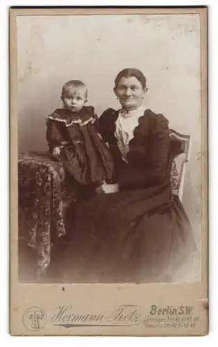 Fotografie Hermann Tietz, Berlin, Leipziger-Str. 46-49, Portrait Mutter im Biedermeierkleid mit Tochter auf dem Tisch