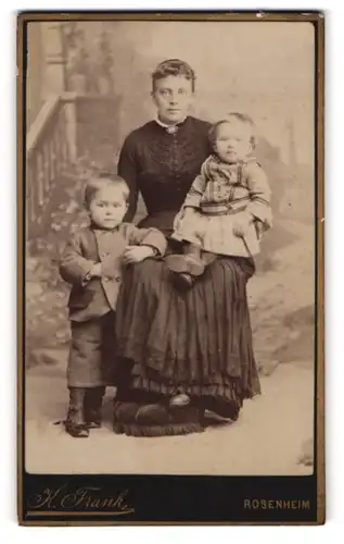 Fotografie K. Frank, Rosenheim, Mutter im schwarzen Kleid mit ihren beiden Kindern, Mutterglück