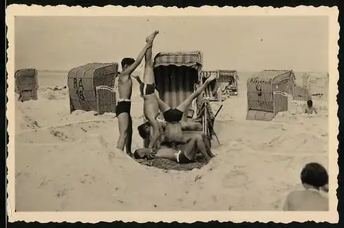 Fotografie Burschen in Badehose bei akrobatischer Vorführung im Strandbad