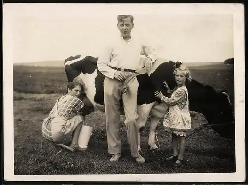 Fotografie Bäuerin beim Melken einer Kuh auf der Weide