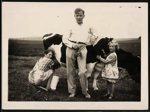 Fotografie Bäuerin melkt eine Kuh auf der Weide