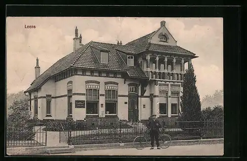 AK Leens, Strassenpartie mit Gebäudeansicht und Mann mit Fahrrad