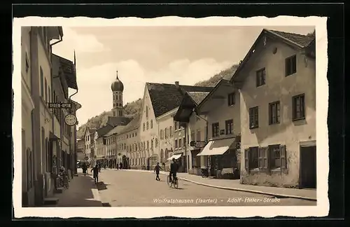 AK Wolfratshausen /Isartal, Strasse mit Geschäften und Kirche