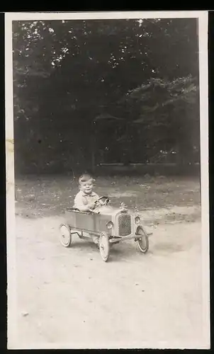 Fotografie Tretauto-Seifenkiste, Knabe fährt mit Spielzeug-Auto