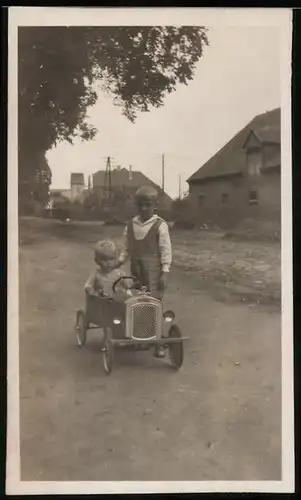 Fotografie Seifenkiste-Tretauto, Kleinkind im Spielzeug-Auto sitzend