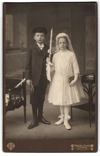 Fotografie Spalke & Kluge, Augsburg, Portrait zwei niedliche Kinder zur Kommunion im Kleid und Anzug mit Kerze