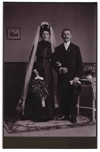 Fotografie Louis Schindhelm, Ebersbach i. S., sächsisches Ehepaar im schwarzen Hochzeitskleid und Anzug mit Zylinder