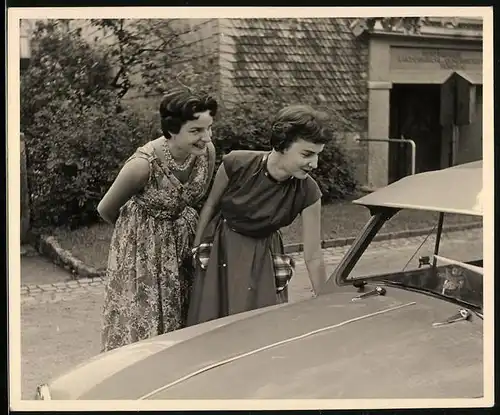 Fotografie Auto, hübsche Damen betrachten PKW mit Sonnenblende