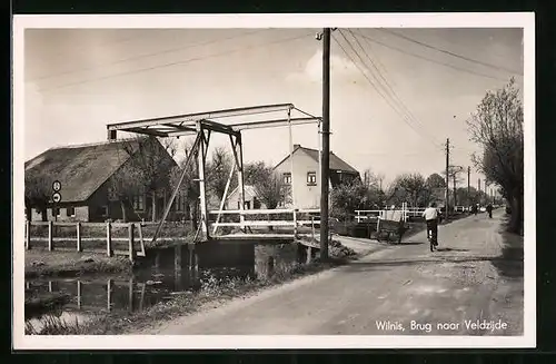 AK Wilnis, Brug naar Veldzijde, Anwohner fährt auf seinem Fahrrad durch den Ort