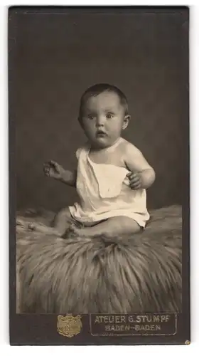 Fotografie G. Stumpf, Baden-Baden, Lichtentaler-Str. 57, Süsses Kleinkind im Hemd sitzt auf Fell