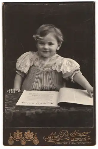 Fotografie Alex Rothberger, Berlin C., Alexander-Platz, Lächelndes kleines Mädchen mit Zeitschrift