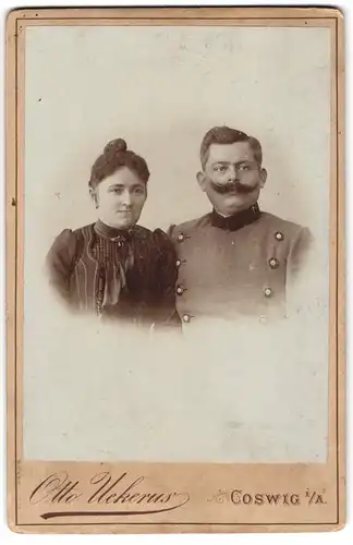 Fotografie Otto Uekerus, Coswig i. A., Soldat mit grossem Schnauzer und Gemahlin mit Dutt