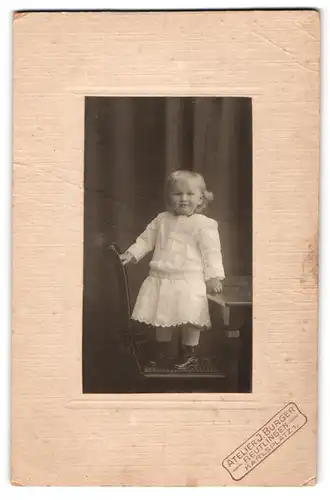 Fotografie J. Burger, Reutlingen, Karlsplatz 1, Kleines Mädchen in weissem Kleid auf Stuhl stehend