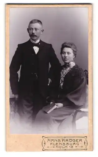 Fotografie Hans Kröger, Flensburg, Holm 12, Bürgerliches elegant gekleidetes Paar, Herr mit Schnurrbart